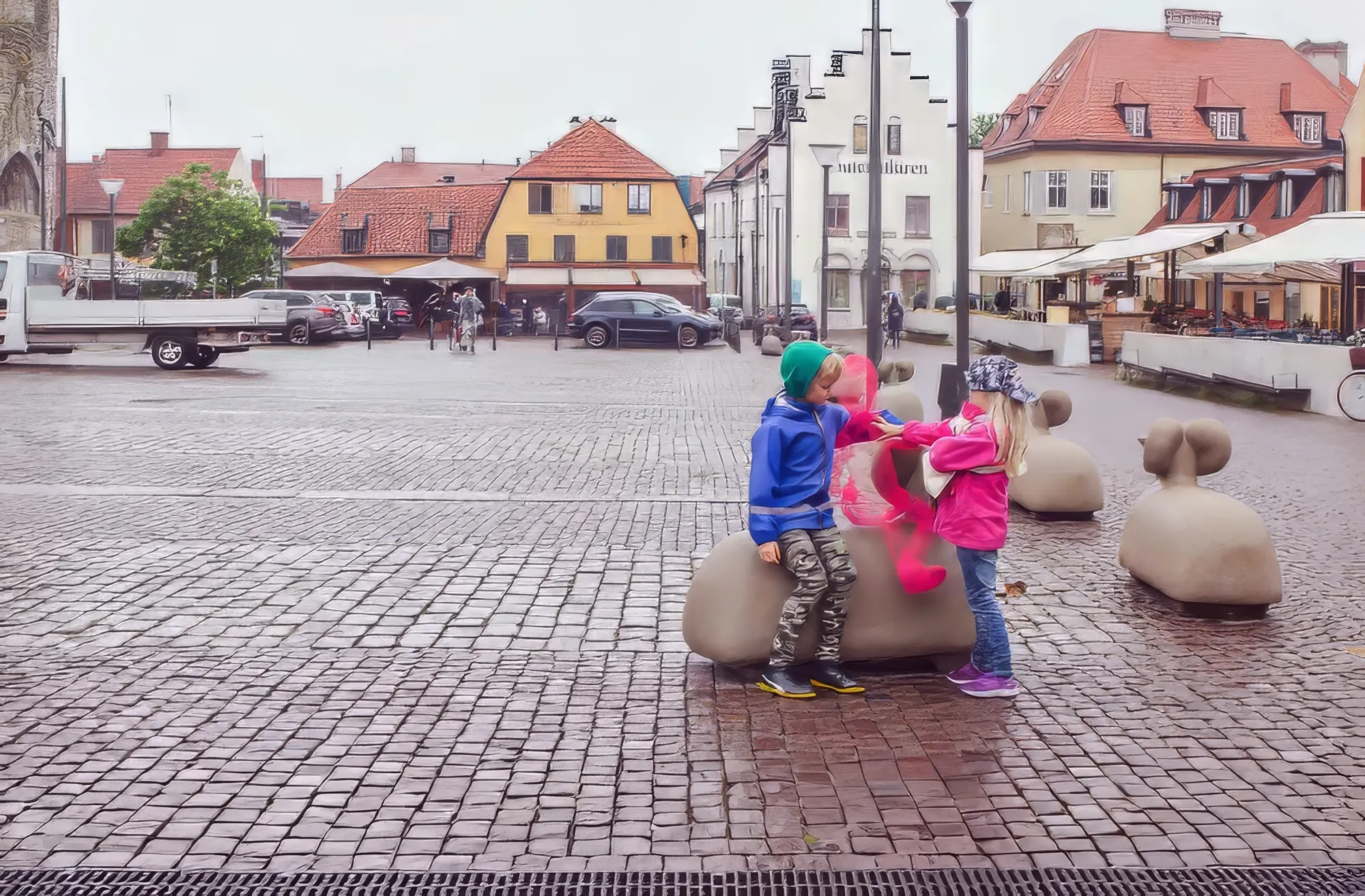 Children handling one of the pink wire figures on a Visby square